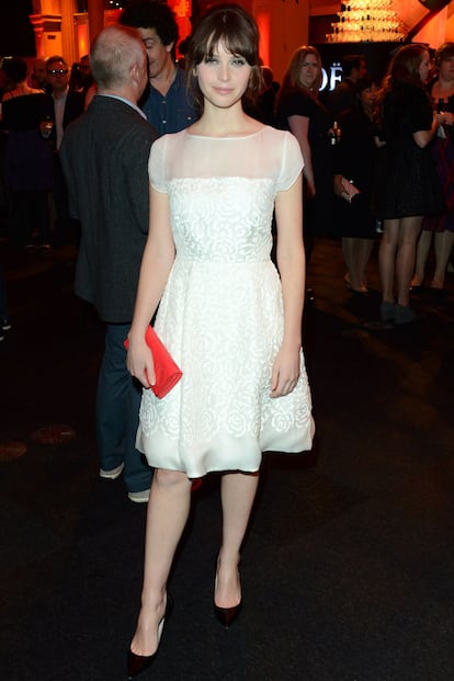 Felicity Jones fiel a su imagen preppy acudió con un sencillo vestido blanco de Christian Dior. El toque de color lo puso su clutch rouge.