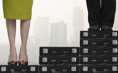 Una mujer y un hombre subidos en pilas de maletines para ilustrar la desigualdad