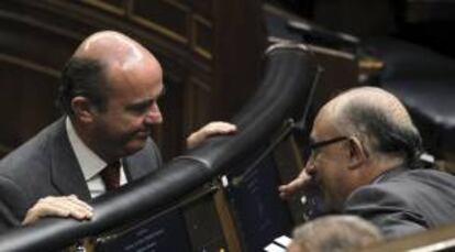 El ministro de Economía, Luis de Guindos (izda), conversa con el ministro de Hacienda, Cristóbal Montoro, al inicio de la sesión de control al Gobierno en el Congreso.