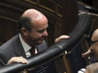 El ministro de Economía, Luis de Guindos (izda), conversa con el ministro de Hacienda, Cristóbal Montoro, al inicio de la sesión de control al Gobierno en el Congreso.