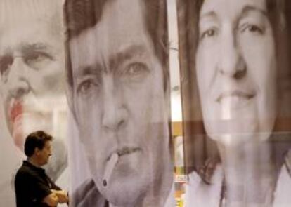 Un hombre observa libros en un stand donde se pueden ver los retratos de los escritores Liliana Bodoc (d), Julio Cortázar (c) y Carlos Fuentes (i), en la 38 Feria Internacional del Libro de Buenos Aires (Argentina). EFE/Archivo