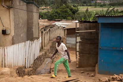 Un joven camina por los suelos de tierra roja de los exteriores del mercado de Mulindi, en Kigali, este 3 de junio.