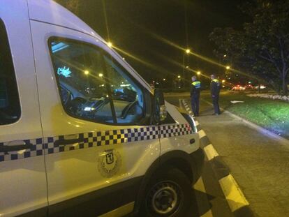 Dos policías municipales observan el vehículo del detenido.