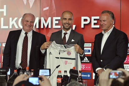 Guardiola posa con la equipación de su nuevo equipo junto al presidente del club, Uli Hoeness, y al presidente del consejo directivo del club, Karl-Heinz Rummenigge.