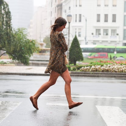 GRAFCAV1060. BILBAO, 28/07/2025.-Una mujer se moja al cruzar un paso de peatones este lunes en Bilbao. La Agencia Estatal de Meteorología (Aemet) da cuenta para este lunes la presencia de una circulación atlántica que afectará al nordeste peninsular y Baleares, con abundante nubosidad y precipitaciones desplazándose por el Cantábrico, alto Ebro, Pirineos, este de Cataluña y Baleares.EFE/Luis Tejido