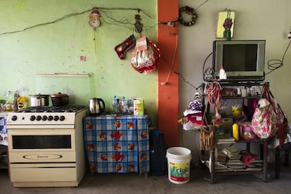 El hogar tiene por dentro las paredes de color pistacho. Algún trozo en blanco por aquí, un desconchón por allá. A modo de decoración, adornos navideños, un globo deshinchado del día de la madre, una bandera de Perú pintada con lápices de colores y un espejo que muestra más rayones que reflejos. Todo cubierto de polvo.