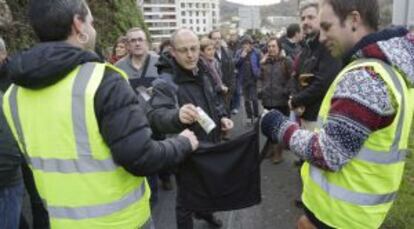 El alcalde de San Sebastián, Juan Karlos Izagirre, entrega su aportación a Sare en la manifestación de este sábado. 
