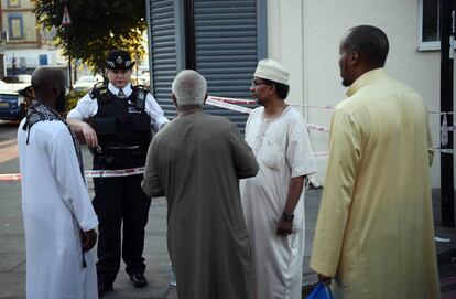 Una agente de policía habla con un grupo de musulmanes cerca de la mezquita de Finsbury Park, en Londres.