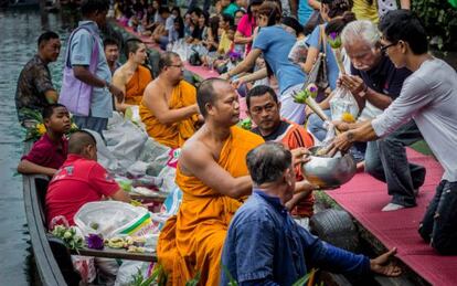 Ofrendas a monjes budistas en el mercado flotante de Kwan Siam, en Bangkok (Tailandia).