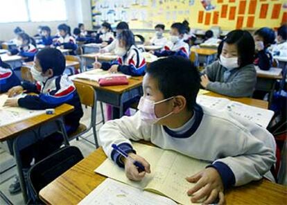 Niños con máscara protectora contra la neumonía, ayer en una escuela de Hong Kong.