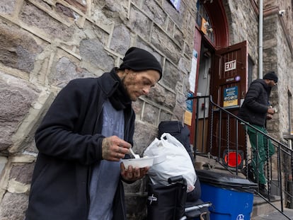 Daniel come su almuerzo en la puerta de Prevention Point, un centro en el que entregan Narcan, agujas y  comida a drogodependientes.