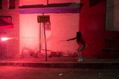 Una joven lanza pólvora de colores hacía otros jóvenes en las esquinas calle abajo de La Perseverancia, el 7 de diciembre.