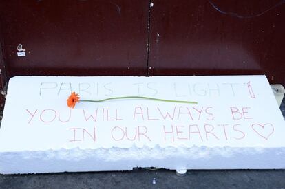 "París es la luz, siempre estarás en nuestros corazones", en letras rojas, con un corazón y una flor.