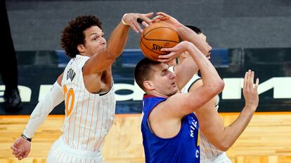 Aaron Gordon le pone un tapón al que será su nuevo compañero Nikola Jokic, en un partido entre Orlando y Denver. ,