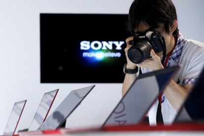 A member of the media takes a photograph with a Pentax K-5 camera of the "red edition" Sony Corp. Vaio Ultrabook laptop computers during a product launch in Tokyo, Japan, on Monday, June 10, 2013. Sony Corp. is Japan's biggest consumer-electronics exporter. Photographer: Kiyoshi Ota/Bloomberg