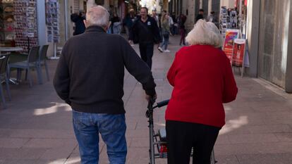 Dos ancianos caminan por una calle de Sevilla.