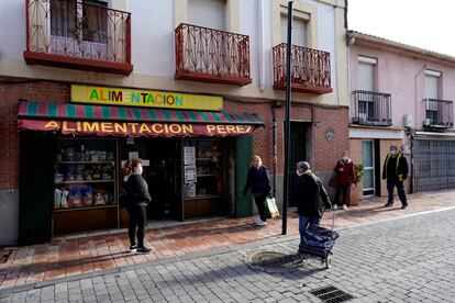 Vecinos de Griñón (Madrid) mantienen la distancia social ante una tienda de alimentación.