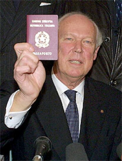 Víctor Manuel muestra su pasaporte italiano a los periodistas.