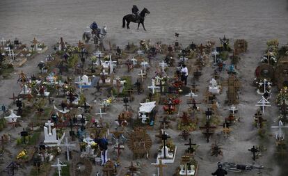 Trabajadores montan a caballo en el cementerio municipal de Valle de Chalco, reservado para enterrar a las víctimas de COVID-19, en las afueras de la Ciudad de México.
