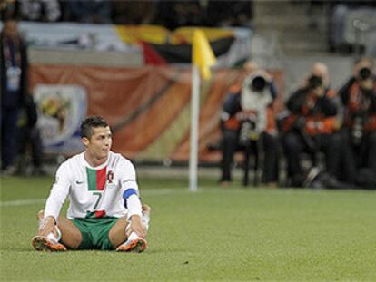Cristiano Ronaldo, sentado en el césped, lamenta una jugada desperdiciada por su equipo durante el partido contra España