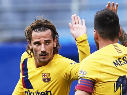 Griezmann y Messi chocan las manos durante un partido.