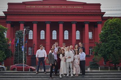 Novios e invitados posan delante de la Universidad Nacional Taras Shevchenko, conocida como La Roja por el color del edificio, donde estudiaron la mayoría.