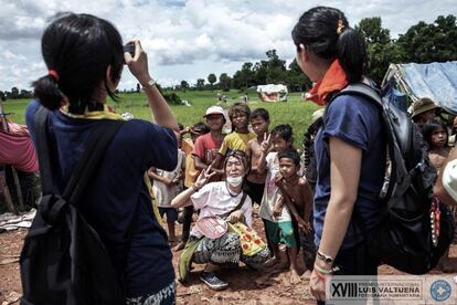 Un camión cargado de residuos llega hasta el basurero de Siem Reap (Camboya). Se estima que en este lugar trabajan unos 20 menores de edad con sus familias. Un turista japonés se fotografía con los niños que trabajan en el basurero. Los turistas dan caramelos y hacen fotos a los menores. La ciudad tiene el vertedero como atracción turística con una ruta especial incluida.