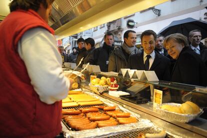 Merkel y Sarkozy ante un puesto de comida en la ciudad alemana de Friburgo, tras el encuentro que mantuvieron ayer.