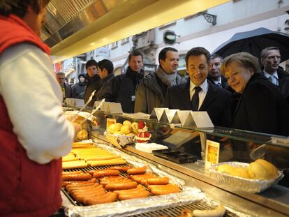 Merkel y Sarkozy ante un puesto de comida en la ciudad alemana de Friburgo, tras el encuentro que mantuvieron ayer.