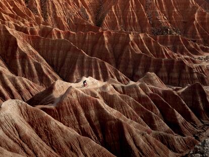 Un ciclista en bici de montaña por el paisaje desértico de las Bardenas Reales (Navarra).