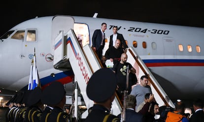 El periodista español Pablo González (tercero por la derecha, bajando las escaleras), junto a varios presos liberados, descienden del avión en Moscú tras el viaje desde Turquía.