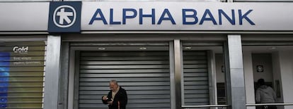 Ciudadanos, delante de una sucursal de Alpha Bank en Atenas.