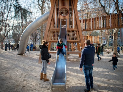 Varios niños juegan en un parque infantil.