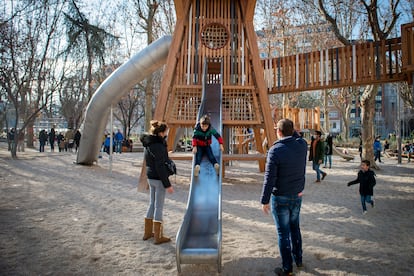 Varios niños juegan en un parque infantil.