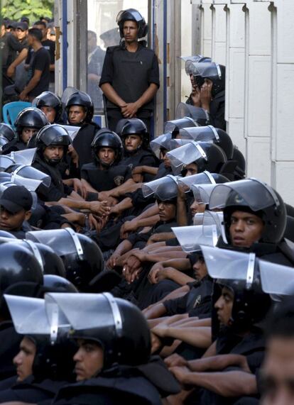 Miembros de las fuerzas de seguridad vigilan el parlamento egipcio mientras cientos de manifestantes egipcios protestan contra al reciente decreto de la Junta Militar.