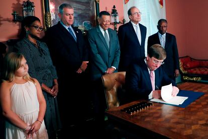 El Gobernador Tate Reeves firma la ley que retira los símbolos confederados de la bandera de Mississippi.