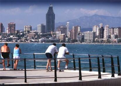 Turistas observan la playa de Poniente de Benidorm desde el mirador del casco antiguo.