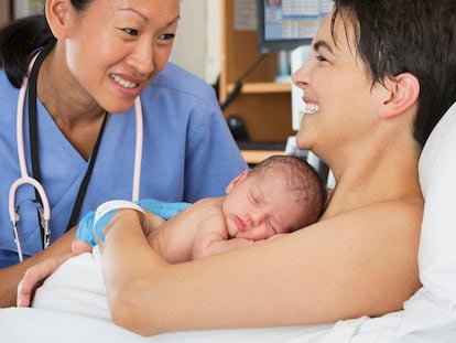 Una enfermera charla con una madre poco después de dar a luz.