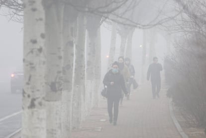 El Índice de Calidad del Aire ha mostrado un nivel de 400 microgramos por metro cúbico en al menos siete ciudades de la provincia de Hebei. En la imagen, varios peatones caminan con mascarillas en Dalian (China).