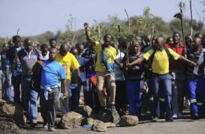 Varios trabajadores de la mina de platino de Lonmin en Marikana protestan mientras permanecen en una nueva huelga ilegal convocada hoy, en la ciudad surafricana de Rustemburg, Sudáfrica, hoy, martes 14 de mayo de 2013.