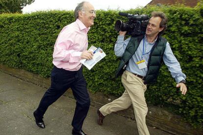 El conservador Michael Howard, acompañado por un camarógrafo ayer en un suburbio cerca de Manchester.