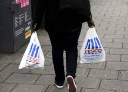 Una mujer camina con las bolsas de la compra de  Tesco en Londres (Reino Unido). EFE/Archivo