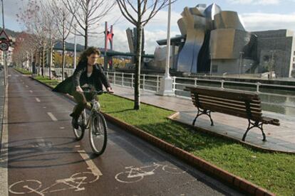 Una joven circula en bicicleta por el <b><i>bidegorri </b></i>de la Avenida de las Universidades, en Bilbao.