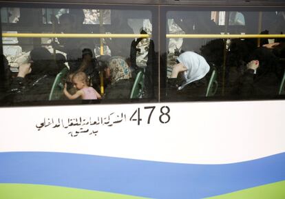 Civiles montan en uno de los autobuses que realiza la evacuación de Daraya hacia otras localidades bajo control del régimen.