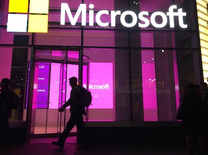 In this Nov. 10, 2016, file photo, people walk past a Microsoft office in New York.