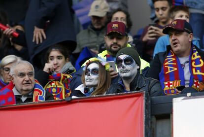 Dos personas caracterizadas para Halloween asisten al partido entre el Barcelona y el Real Madrid en el Camp Nou, el 28 de octubre de 2018.