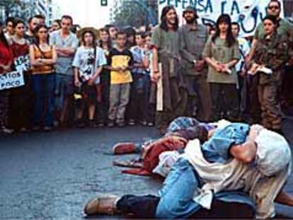 Dramatización antimilitarista durante la marcha de protesta con la celebración de l Día de las fuerzas Armadas en Alicante, ayer.