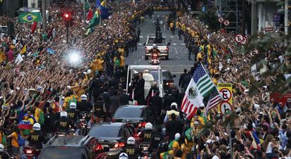 El papamóvil circula por una calle abarrotada de gente en el centro de Río de Janeiro.