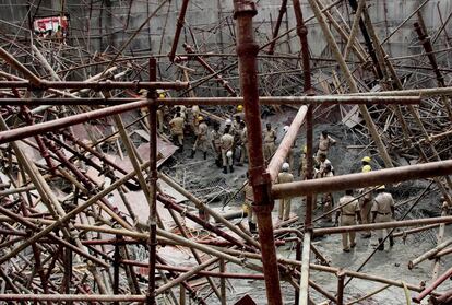 Efectivos de los bomberos y la Fuerza Nacional de Respuesta a Desastres buscan supervivientes en un depósito de agua en construcción que se derrumbó en Bangalore (India). Al menos tres personas han muerto y otras 20 resultaron heridas en el suceso.