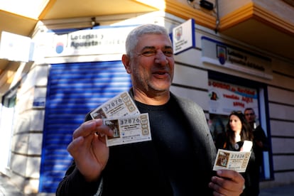 Un hombre muestra sus tres décimos con el número 37876 de un quinto premio, en la administración número 16 de Elche (Alicante).